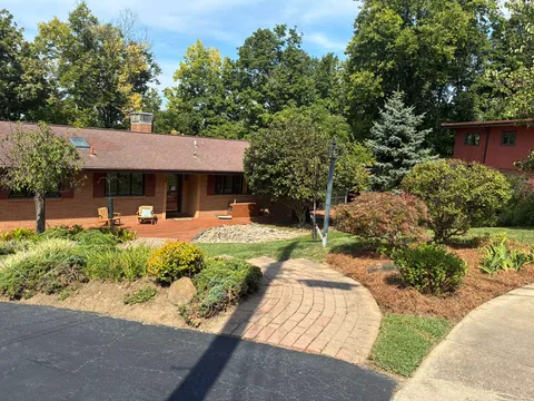 Landscaped front yard with mulched garden beds and a curved paver walkway